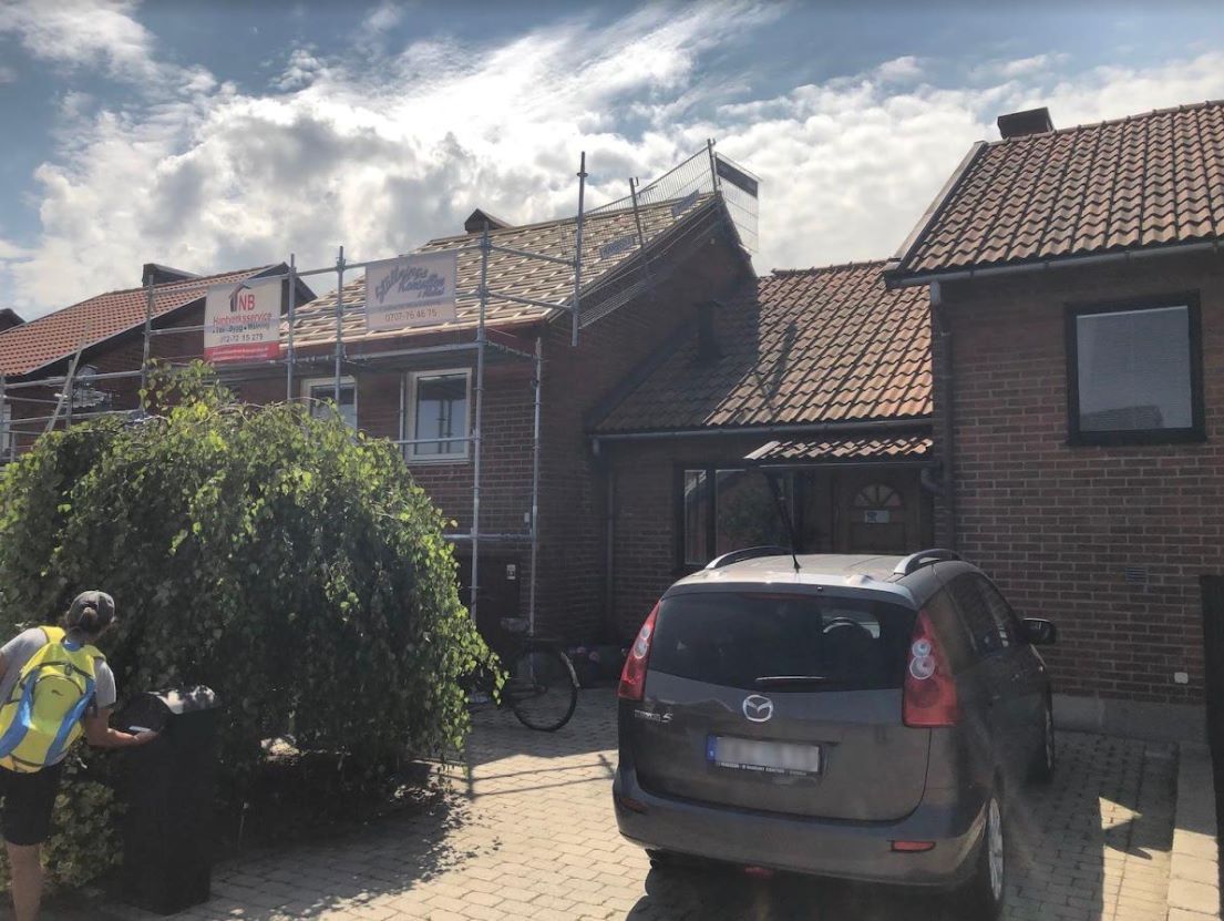 Byggställning uppsatt längs tegelhus.